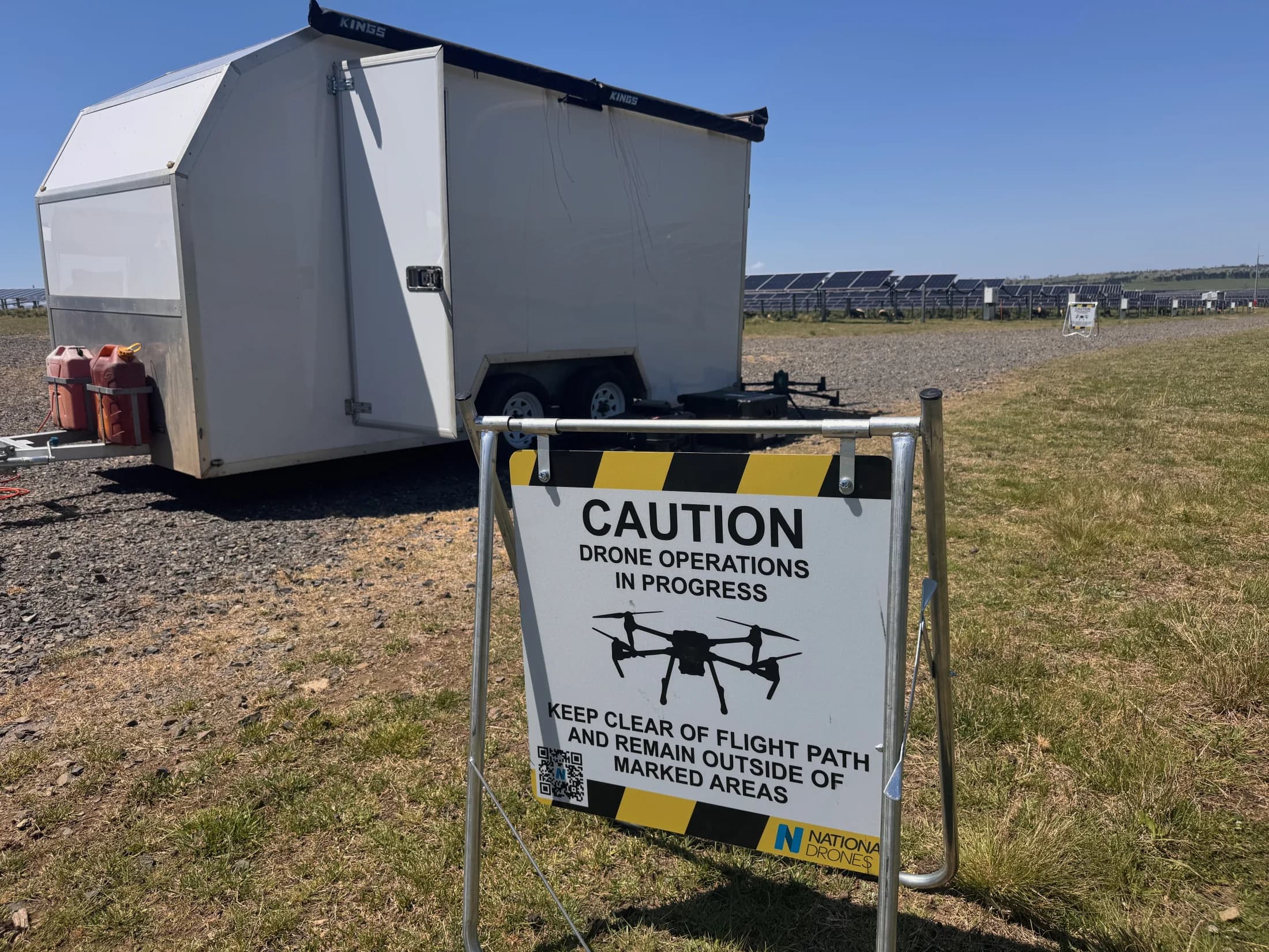 Drone operations safety sign beside a mobile field trailer at an infrastructure site